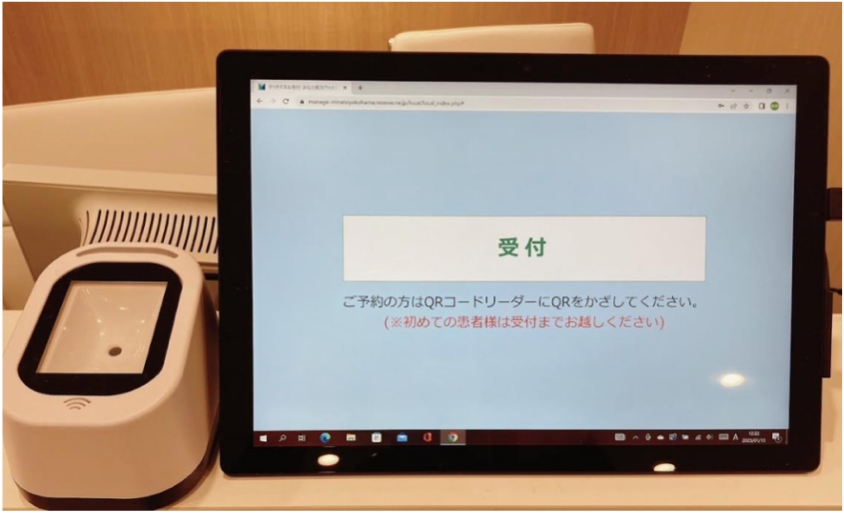 受付でQRコードを再診機にタッチして保険証を提出してください